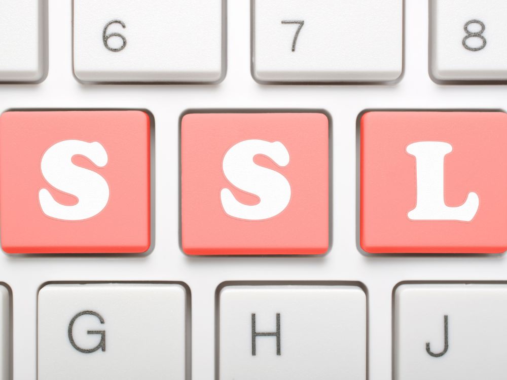 Teclas de teclado destacando as letras SSL em vermelho, simbolizando a importância do SSL para proteção e confiança online.