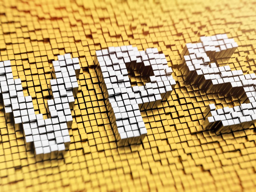 As letras "VPS" formadas por blocos 3D brancos, destacando-se sobre um fundo texturizado de blocos dourados. A imagem visualiza o conceito de Virtual Private Server. O que é VPS em sua forma mais fundamental.