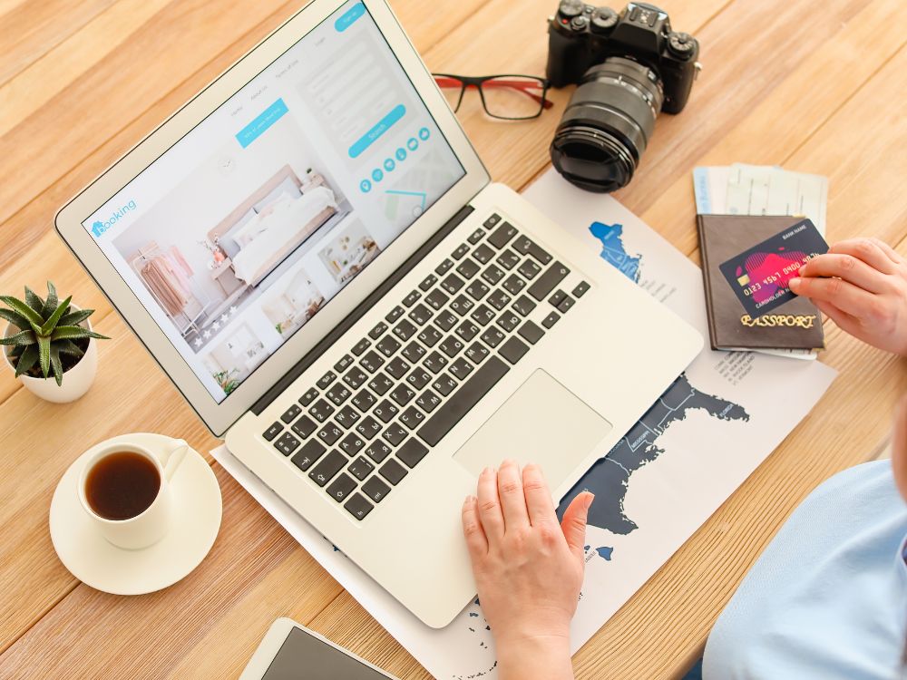 Pessoa digitando em notebook com página de reservas online, ilustrando o desenvolvimento de um Site para SEO otimizado para conversão e experiência do usuário.